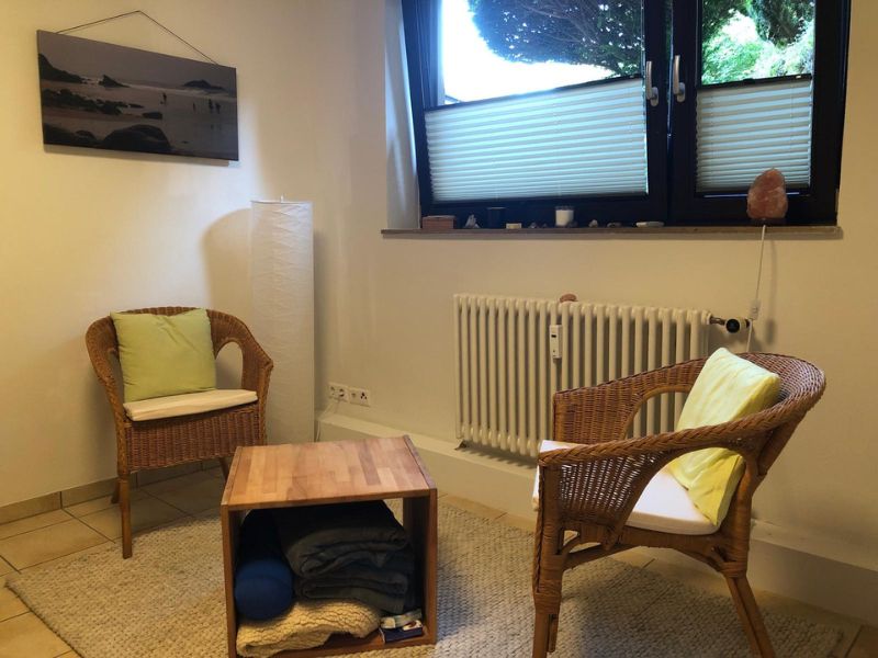 Zwei gemütliche Stühle und ein Couchtisch in der Praxis. Susanne Lohse bietet Stressabbau in Karlsruhe an