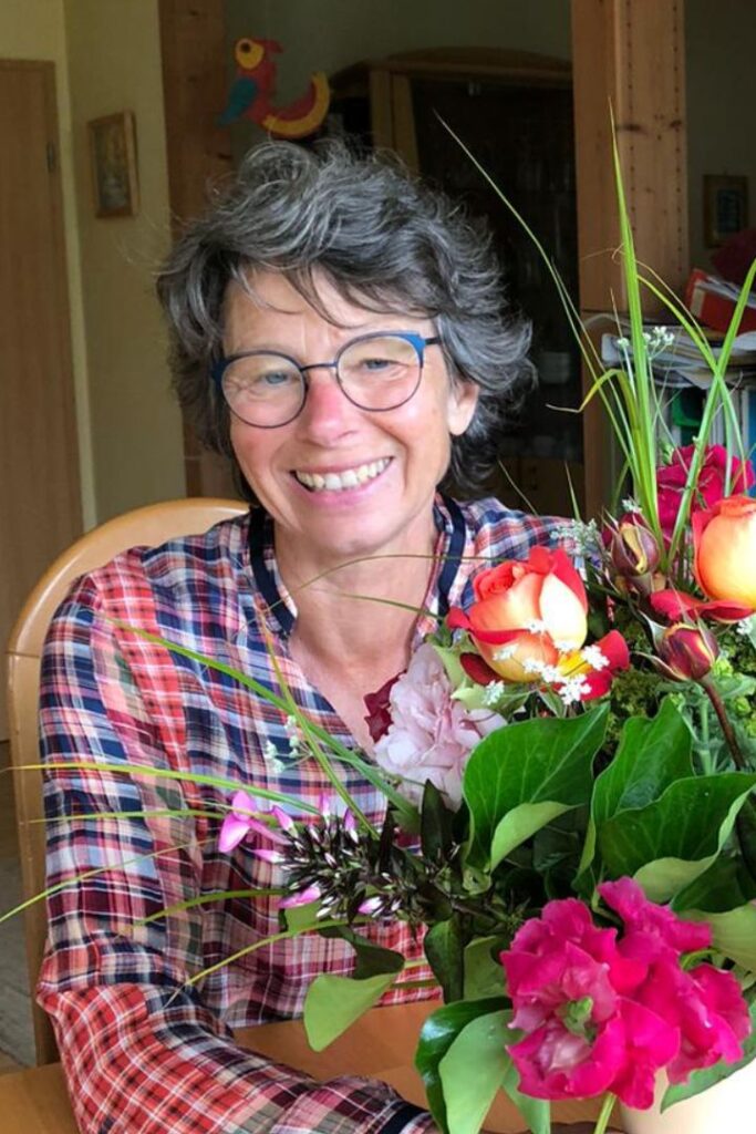 Susanne Lohse mit einem üppigen Blumenstrauß. Sie bietet Stressbewältigung in Karlsruhe an.